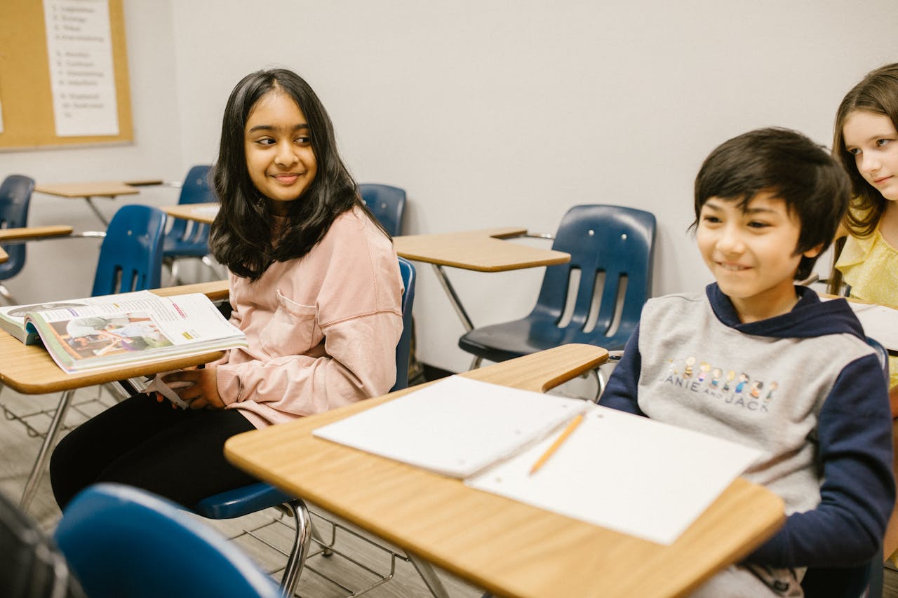 Students smiling and interacting in a cheerful classroom setting, fostering education and cultural diversity.